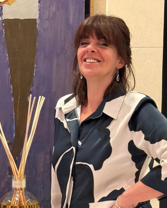 Retrato de Mariana Rey, sonriente, con vestido estampado